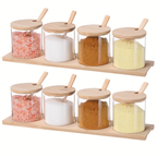 Eight 10-ounce clear glass spice jars with wooden lids and spoons.